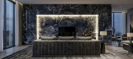 Backlit black onyx wall behind a living-room sofa