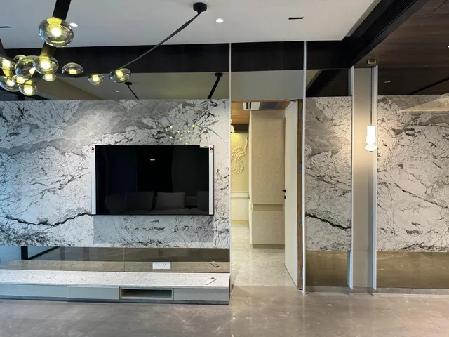 White marble TV wall with bold grey veining in a living room